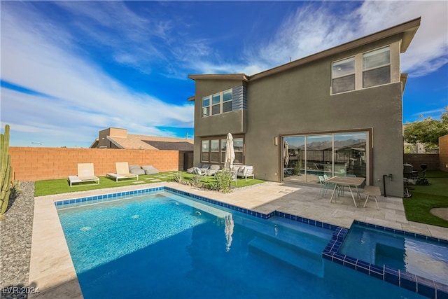 rear view of property with a patio and a fenced in pool