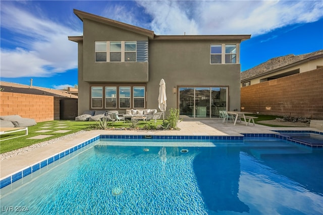 back of property featuring outdoor lounge area, a fenced in pool, and a patio area