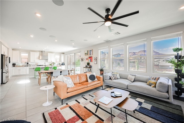 living room featuring plenty of natural light, light tile patterned floors, and ceiling fan