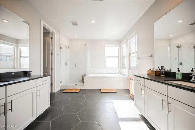 bathroom featuring independent shower and bath, vanity, and tile patterned flooring