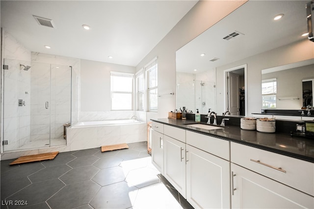 bathroom with a wealth of natural light, tile patterned flooring, vanity, and separate shower and tub