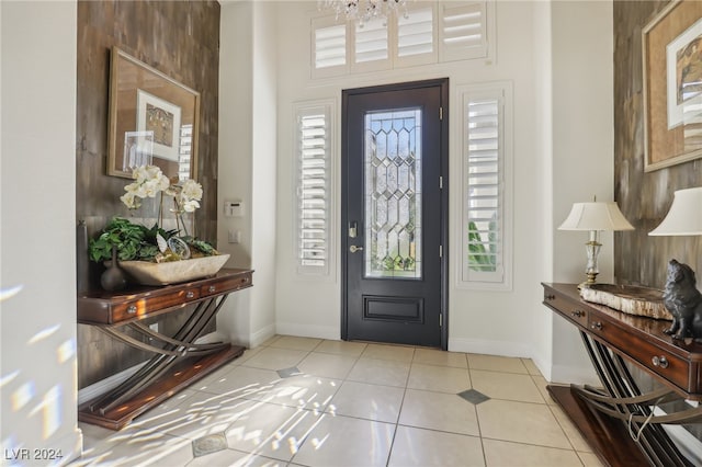 entryway with light tile patterned floors and a chandelier