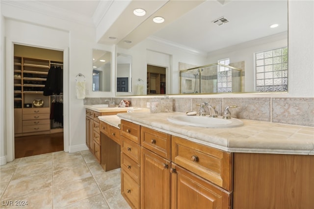 bathroom with vanity, decorative backsplash, a shower with shower door, and ornamental molding