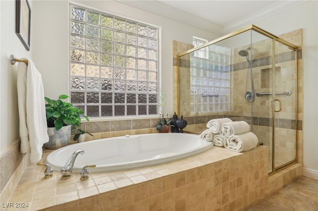 bathroom featuring crown molding and separate shower and tub