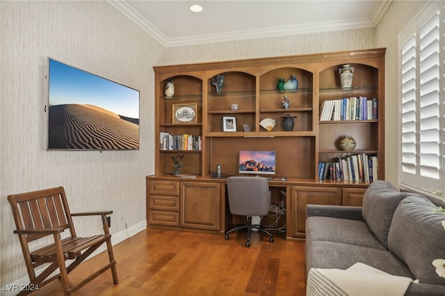 home office featuring dark wood-type flooring, built in desk, and ornamental molding