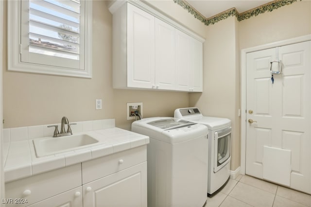 laundry room featuring washer and dryer, cabinets, sink, and light tile patterned floors