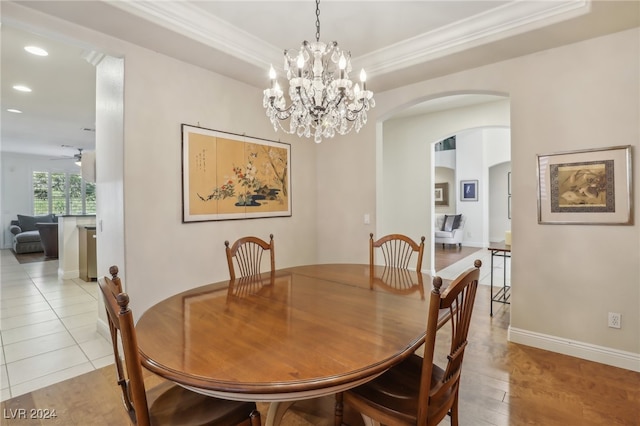 dining area featuring crown molding, light hardwood / wood-style flooring, and ceiling fan with notable chandelier