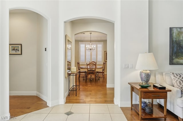 hall featuring light hardwood / wood-style floors and a chandelier