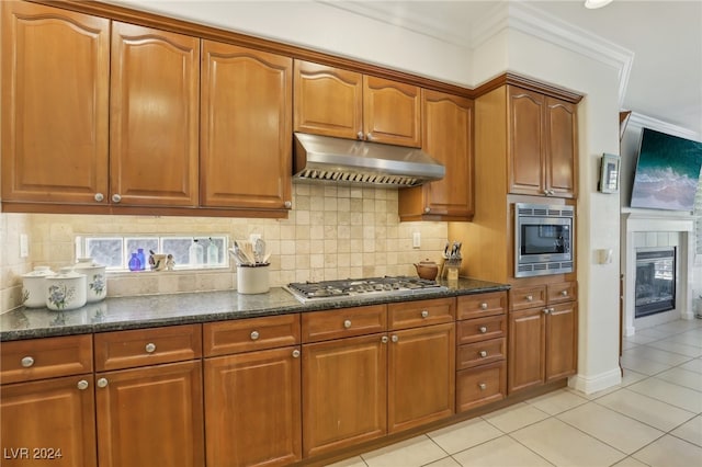 kitchen featuring appliances with stainless steel finishes, crown molding, backsplash, and light tile patterned floors