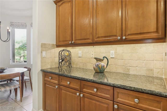 kitchen with dark stone countertops, tasteful backsplash, and light tile patterned floors