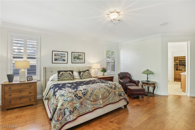 bedroom with light hardwood / wood-style flooring, multiple windows, and ornamental molding