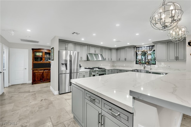 kitchen featuring gray cabinetry, appliances with stainless steel finishes, pendant lighting, light stone countertops, and sink