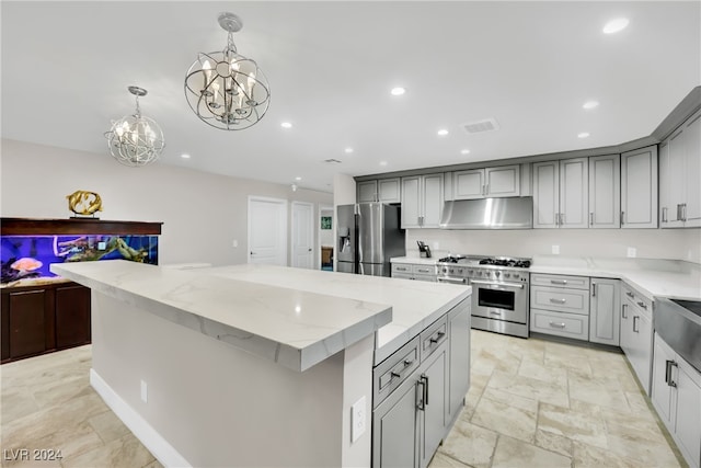 kitchen with range hood, appliances with stainless steel finishes, decorative light fixtures, a large island, and gray cabinets