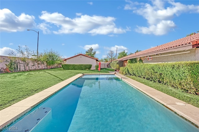 view of pool featuring a lawn