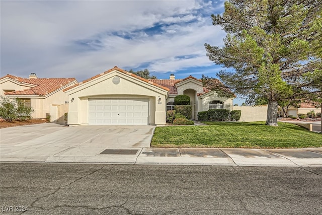 mediterranean / spanish house featuring a front lawn and a garage