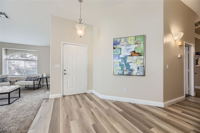 entrance foyer with high vaulted ceiling and hardwood / wood-style flooring