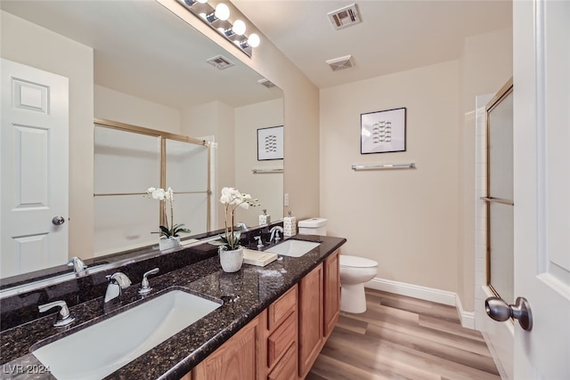 bathroom featuring a shower with door, hardwood / wood-style flooring, toilet, and vanity