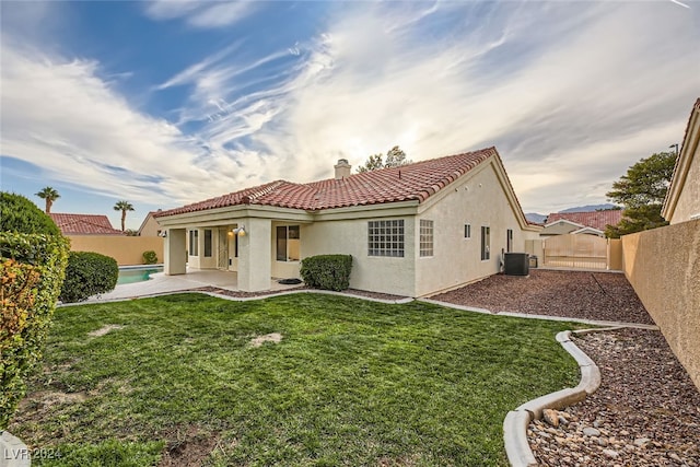 rear view of house featuring a fenced in pool, a lawn, a patio area, and central AC unit