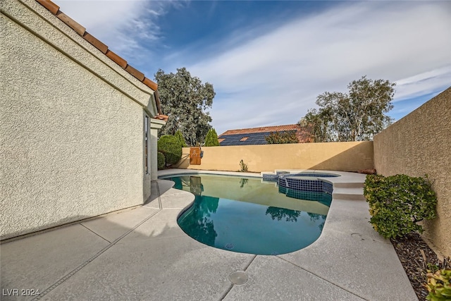 view of swimming pool featuring a patio and an in ground hot tub