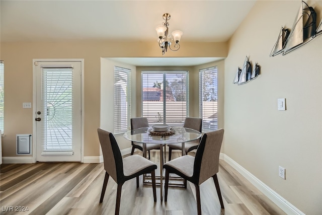 dining area with hardwood / wood-style floors and a notable chandelier