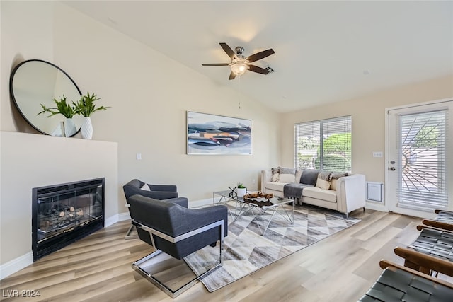 living room featuring light hardwood / wood-style floors, ceiling fan, and vaulted ceiling