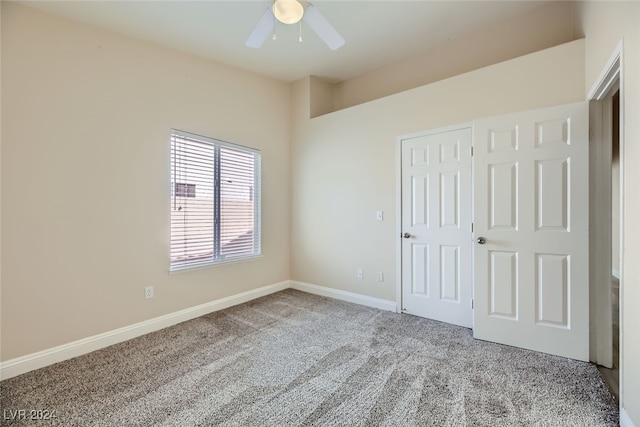 unfurnished bedroom featuring a closet, light colored carpet, and ceiling fan