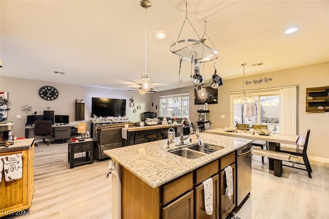 kitchen with a wealth of natural light, sink, pendant lighting, and light wood-type flooring