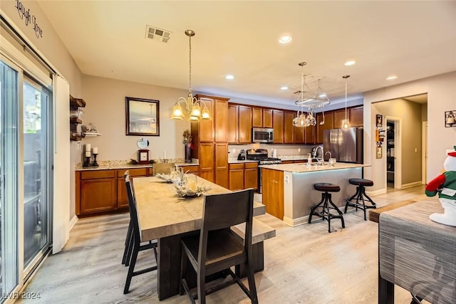 dining space featuring light hardwood / wood-style floors, sink, and an inviting chandelier