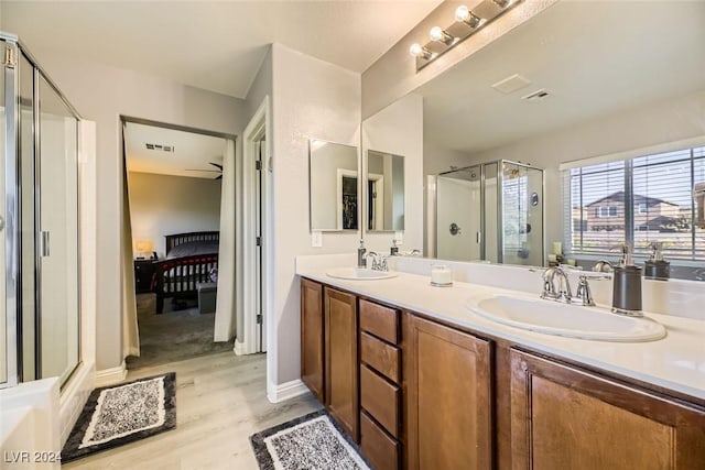 bathroom with hardwood / wood-style floors, vanity, and an enclosed shower