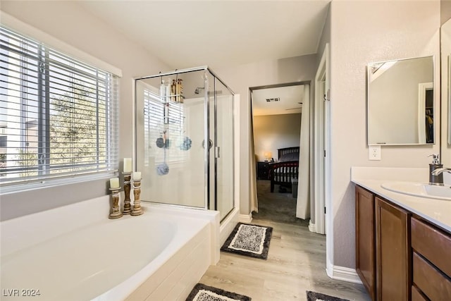 bathroom with hardwood / wood-style floors, vanity, a healthy amount of sunlight, and shower with separate bathtub