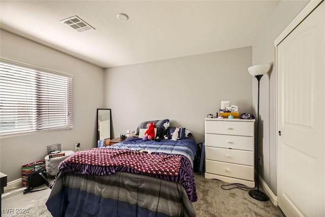 bedroom featuring light carpet and a closet