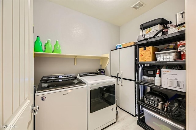 clothes washing area featuring separate washer and dryer