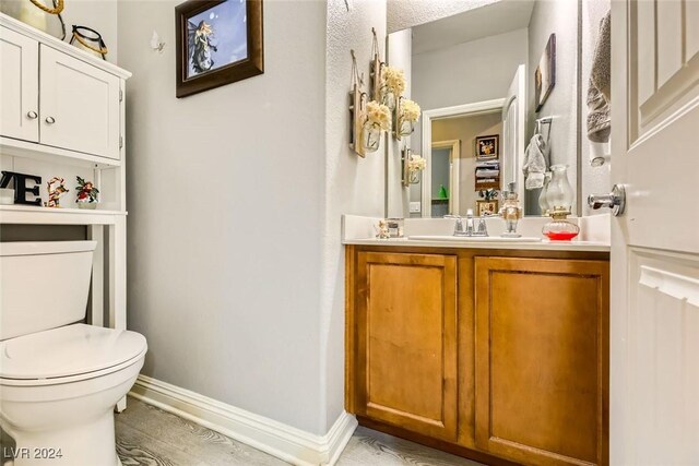 bathroom featuring hardwood / wood-style floors, vanity, and toilet