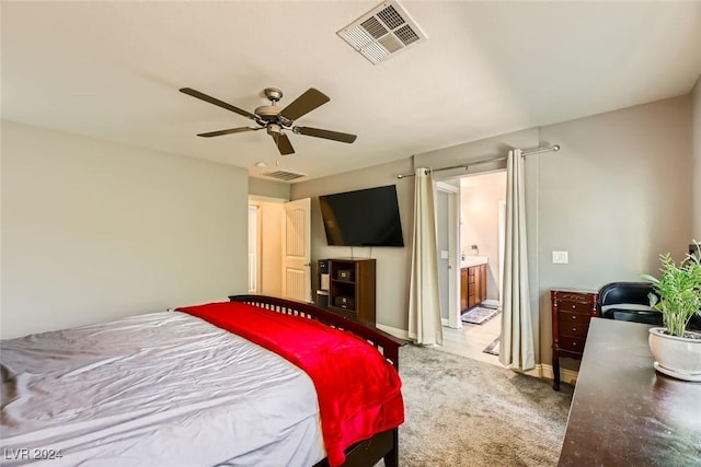 carpeted bedroom featuring ceiling fan and ensuite bathroom