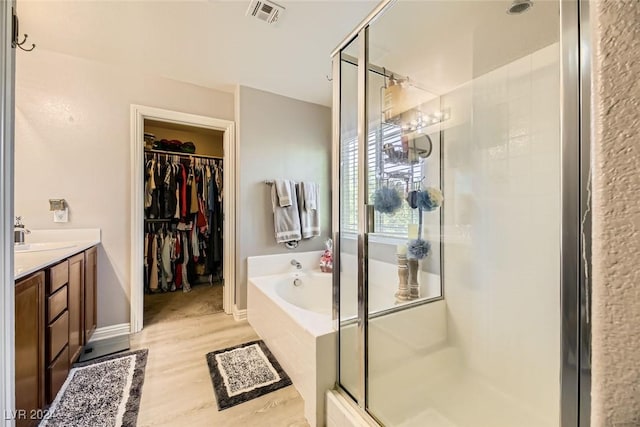 bathroom featuring hardwood / wood-style floors, vanity, and independent shower and bath