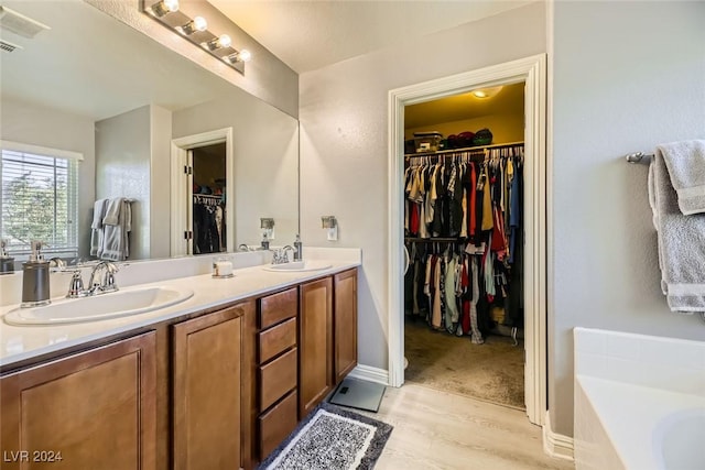 bathroom with hardwood / wood-style floors, vanity, and a bathtub