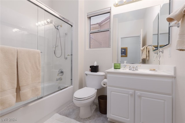 full bathroom featuring vanity, shower / bath combination with glass door, toilet, and tile patterned flooring