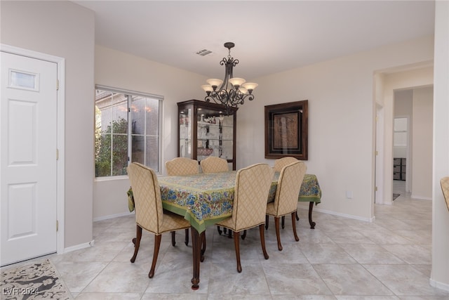 tiled dining space with an inviting chandelier