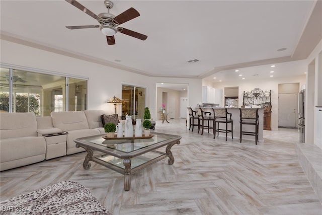 living room featuring ornamental molding, light parquet floors, and ceiling fan