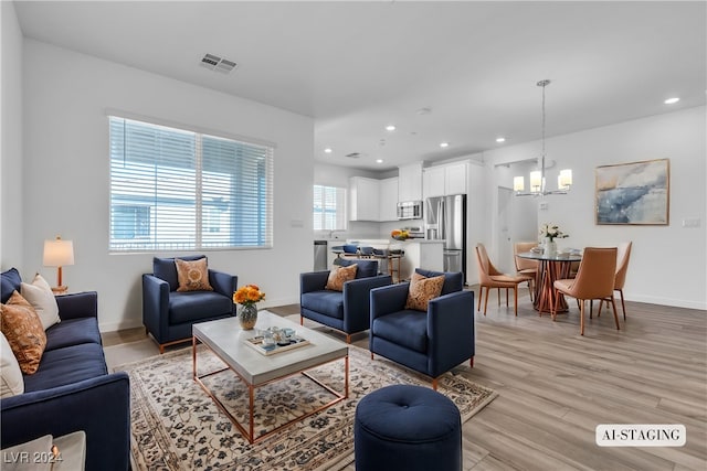 living room featuring light hardwood / wood-style flooring and a notable chandelier