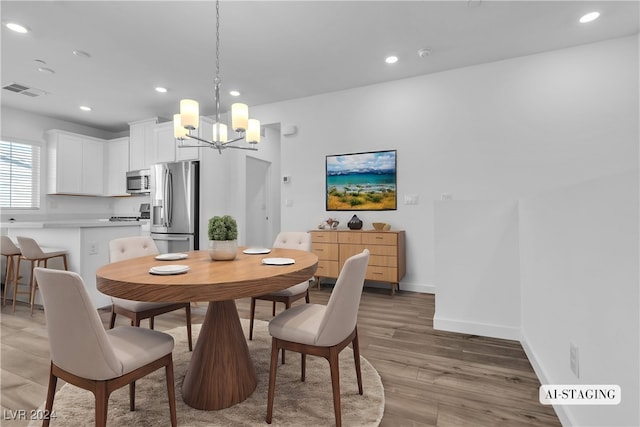 dining area with hardwood / wood-style floors and a chandelier