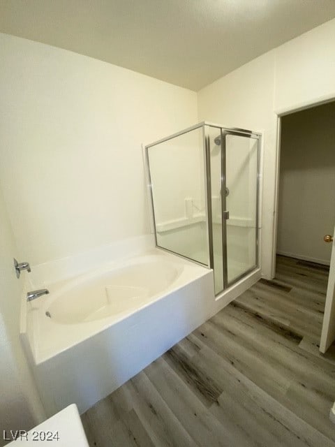 bathroom with wood-type flooring and separate shower and tub