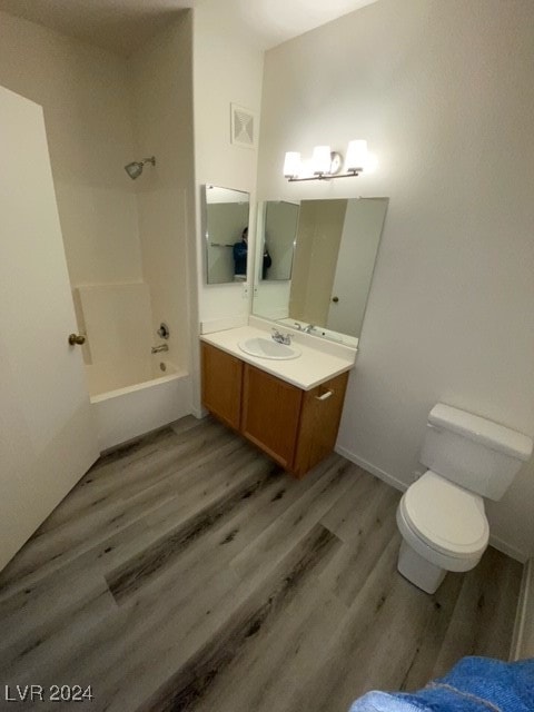 full bathroom featuring vanity, hardwood / wood-style floors, toilet, and tub / shower combination