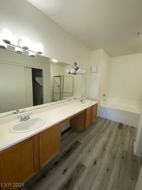 bathroom with vanity, separate shower and tub, and hardwood / wood-style flooring