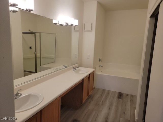 bathroom with vanity, shower with separate bathtub, and hardwood / wood-style floors