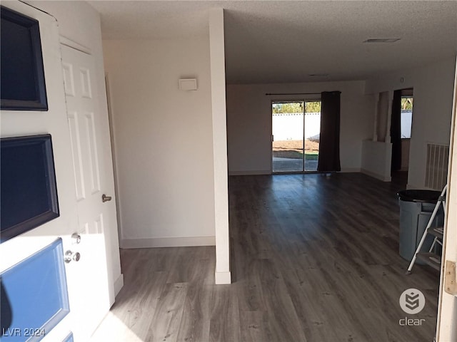 unfurnished room with a textured ceiling and hardwood / wood-style flooring