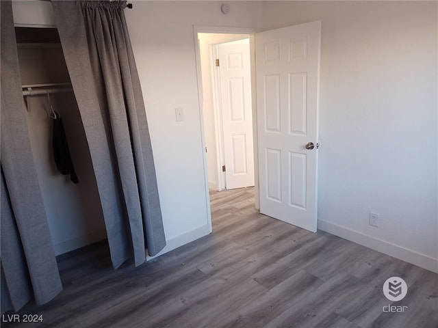 unfurnished bedroom with a closet and hardwood / wood-style flooring