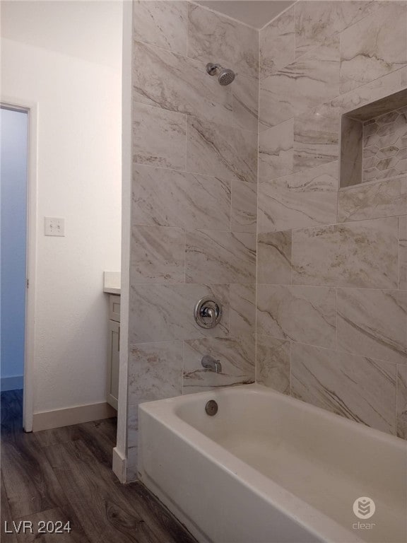 bathroom featuring tiled shower / bath combo, wood-type flooring, and vanity