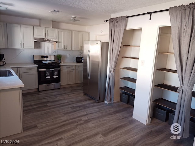 kitchen featuring a textured ceiling, white cabinets, dark hardwood / wood-style flooring, and stainless steel appliances