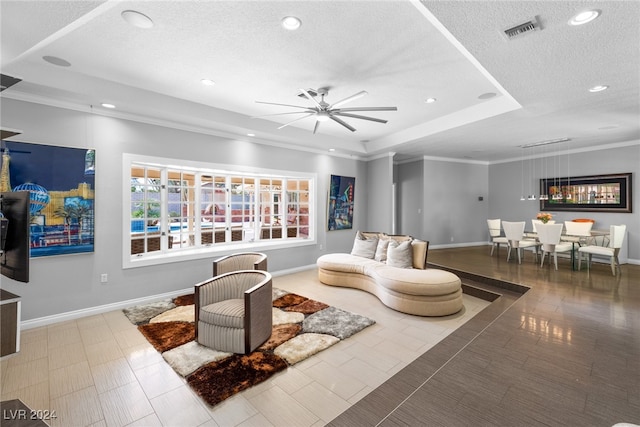 living room featuring ornamental molding, a textured ceiling, and ceiling fan